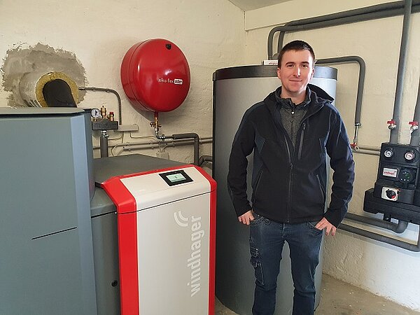 Le ramoneur Bernhard Peer avec la chaudière à pellets BioWIN2 Touch